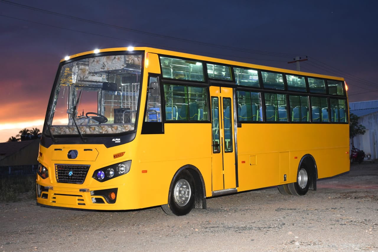 Yellow institutional bus body built by Alfha Coach Builders, Karur, photographed at dusk