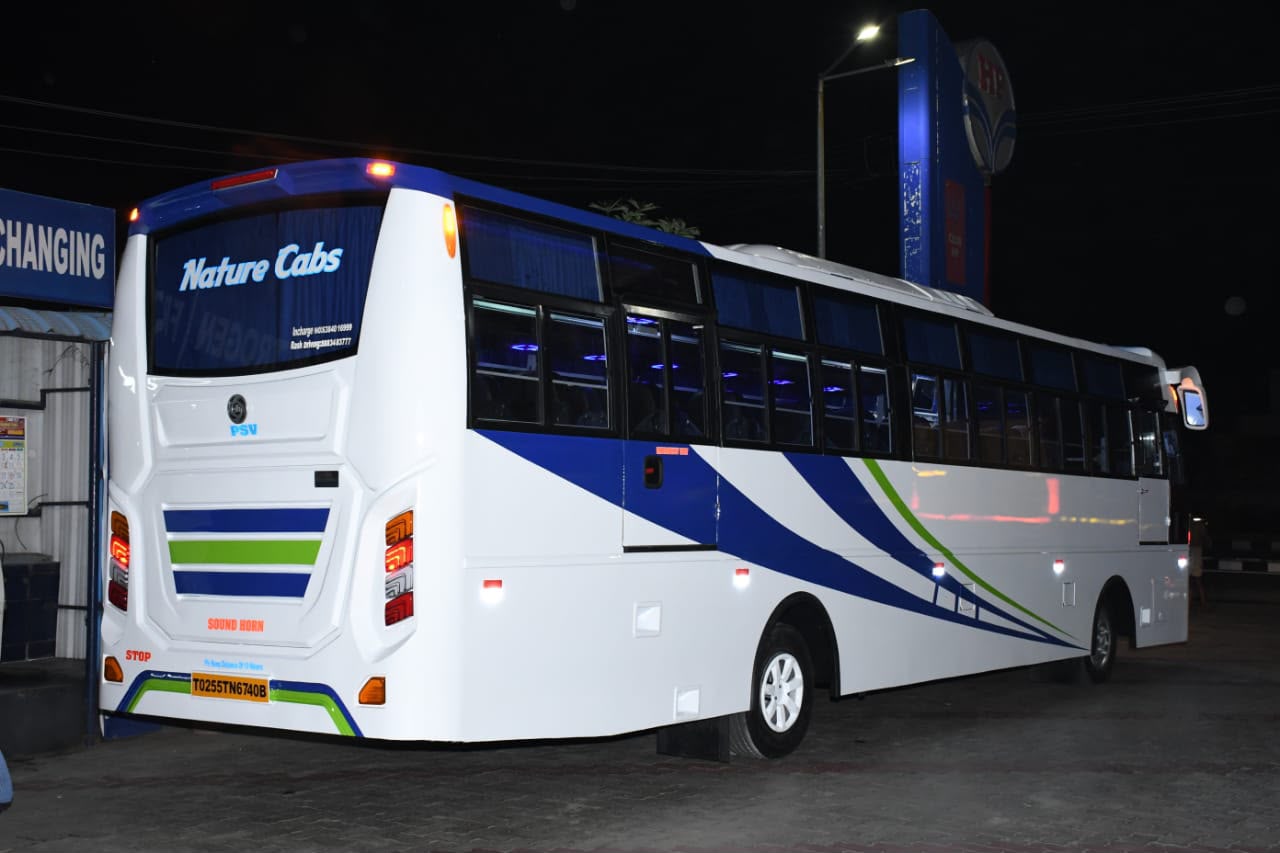 White staff transport coach with blue and green graphics built by Alfha Coach Builders, Karur